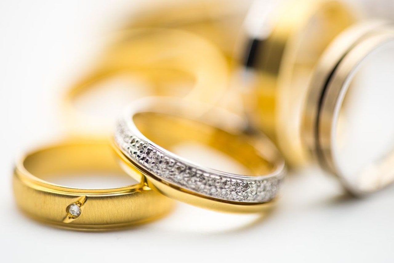 A collection of women and men’s wedding bands feature gold and diamonds