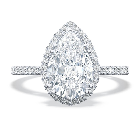 A pear-shaped diamond ring with a halo setting glimmers on a white background.