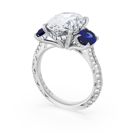 Luxurious ring with a large oval diamond centerpiece flanked by two deep blue sapphires.