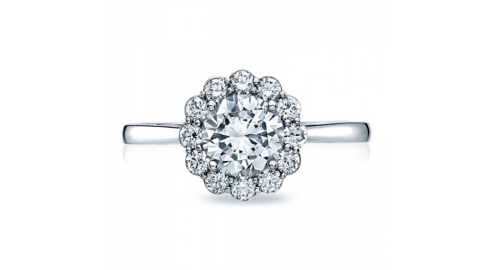 a white gold engagement ring featuring a round cut center stone and a floral-inspired halo