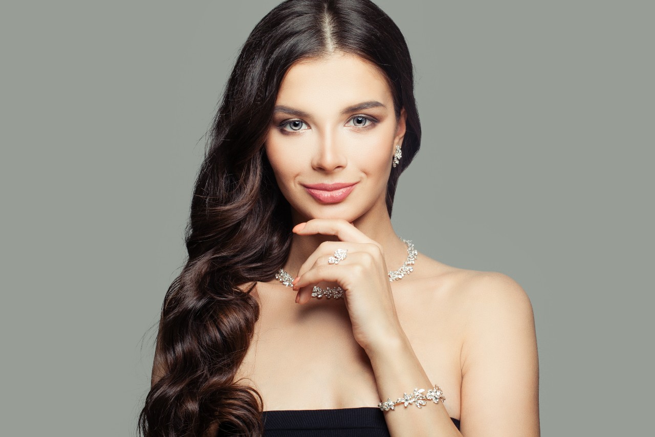 a woman wearing diamond earring, diamond ring, diamond necklace and diamond bracelet