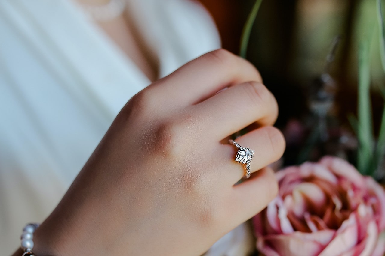 A close-up of a marquise diamond white gold engagement ring on a bride’s hand